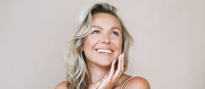 Smiling woman touching her face