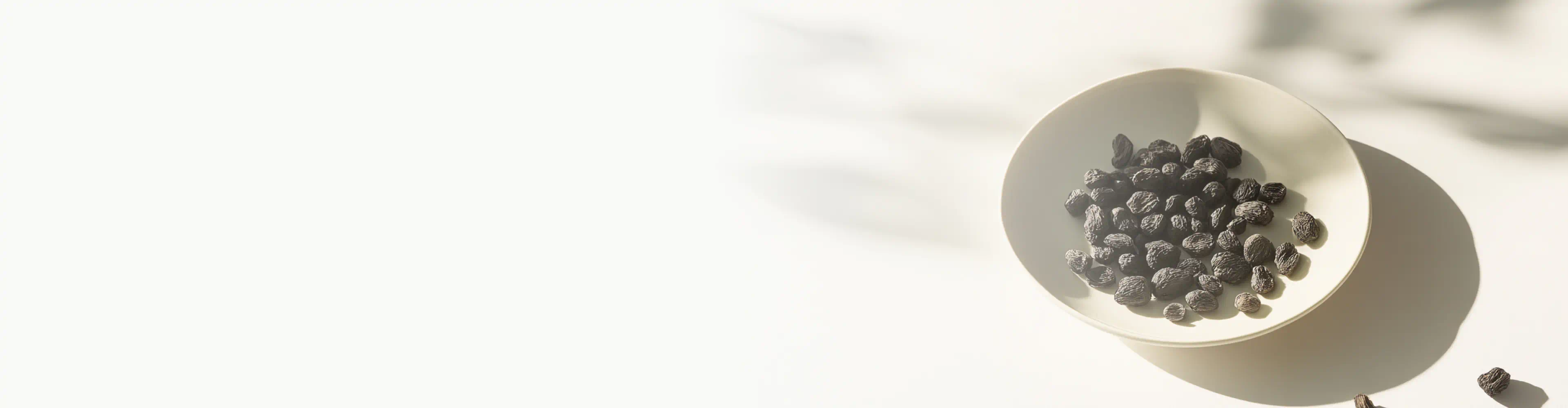 A bowl filled with small, dark, wrinkled Bakuchiol seeds